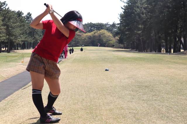 ゴルフの素振りをする女性